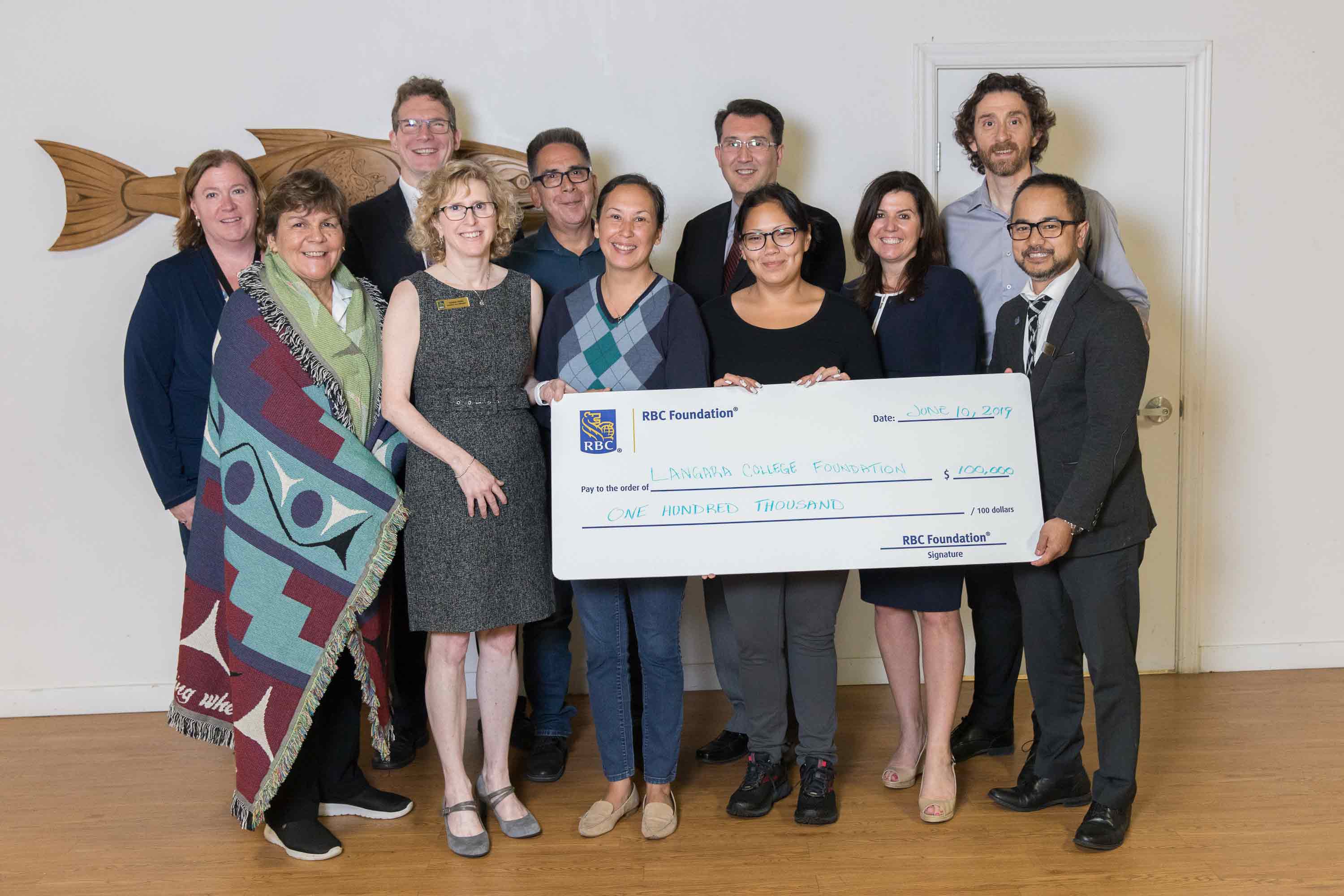 Group of people posing holding a cheque