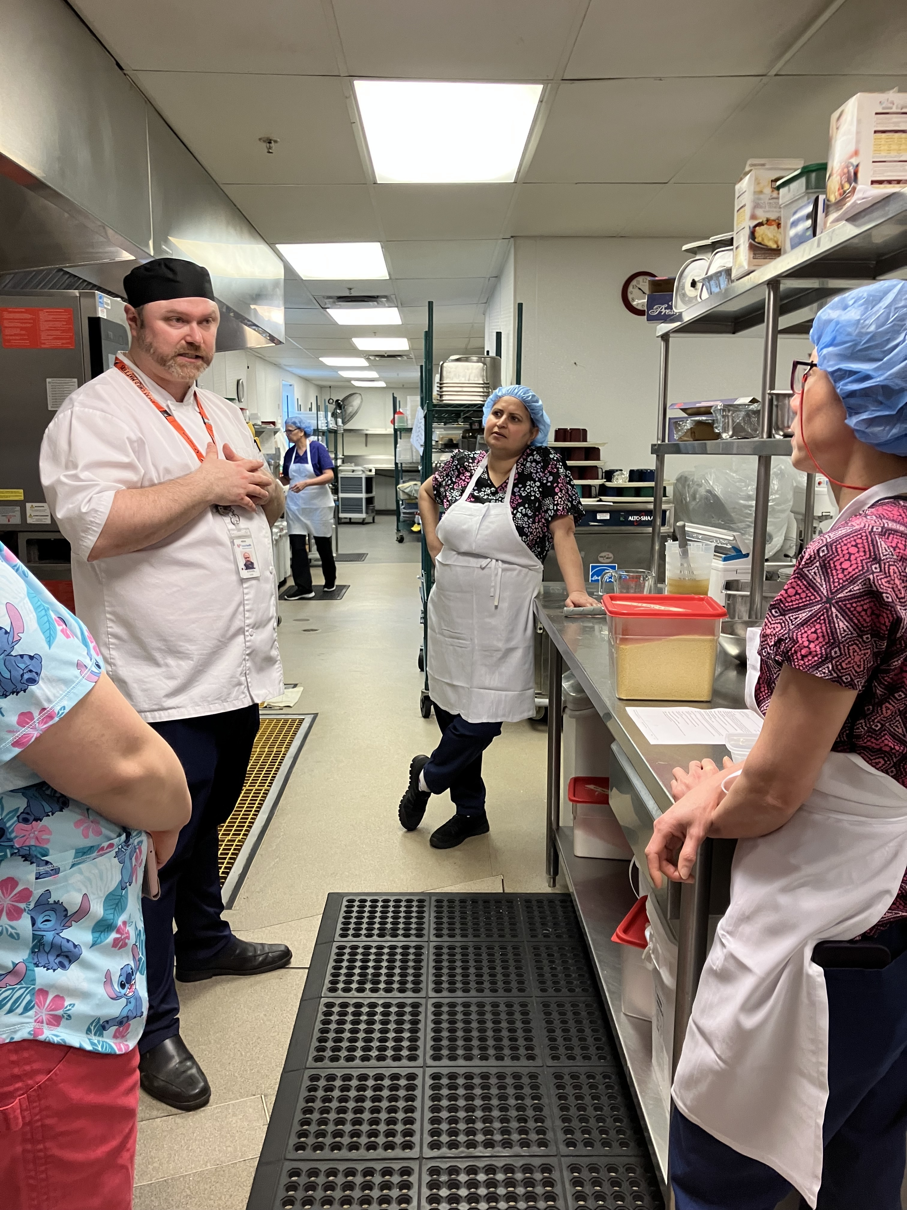 Chef Steven Courtney with his team in a commercial kitchen.