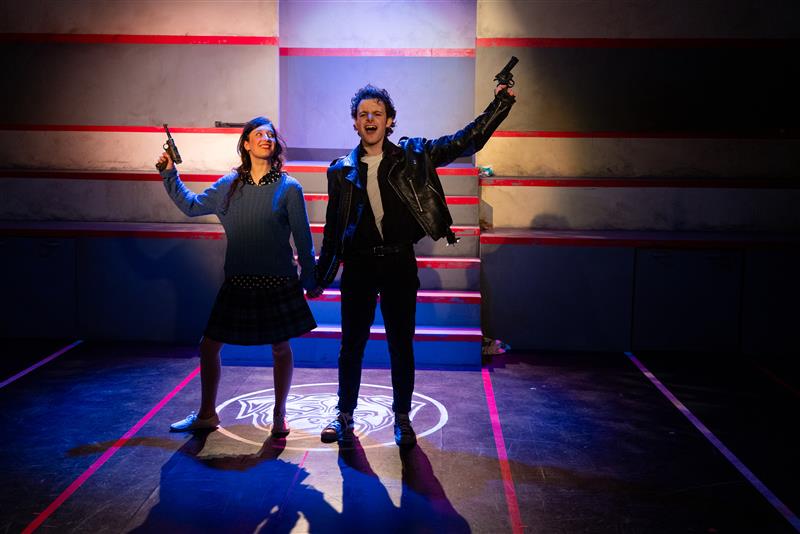 Saidi Mader as Veronica Sawyer and Evan Andersen Sterns as J.D. in Heathers: The Musical (2025) at Studio 58. Photo by Moonrider Productions; Directed and Choreographed by Julie Tomaino; Assistant Directed by Ivy Charles; Assistant Choreographed by Tiana Jung; Set and Props Design by Pam Johnson; Costume Design by Alaia Hamer; Assistant Costume Design by Sarah Sosick; Lighting Design by Jonathan Kim.