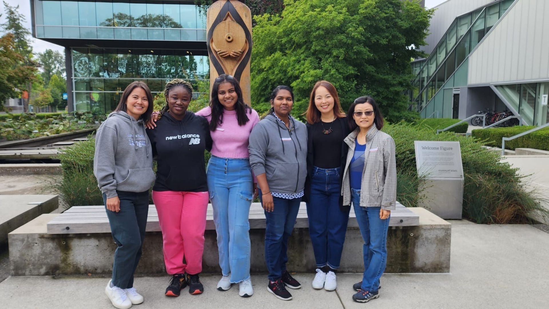 Angeline (left) with her Gerontology diploma classmates pose in front of the totem pole on Langara's main campus.
