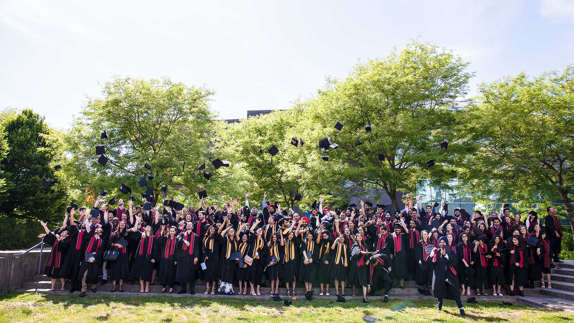 Graduates throwing their caps outside T-building
