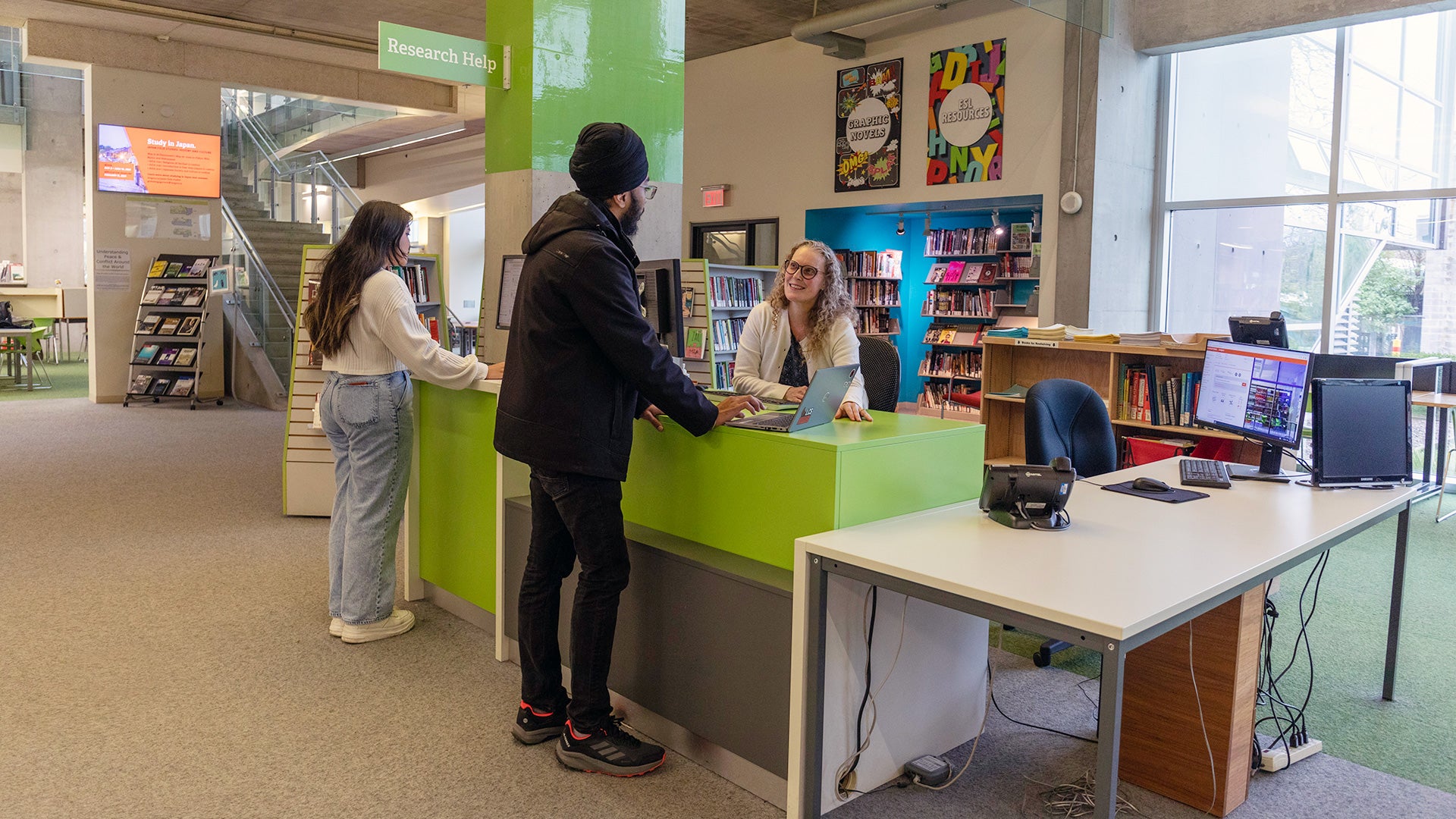 A student is receiving assistance at the library with their research.