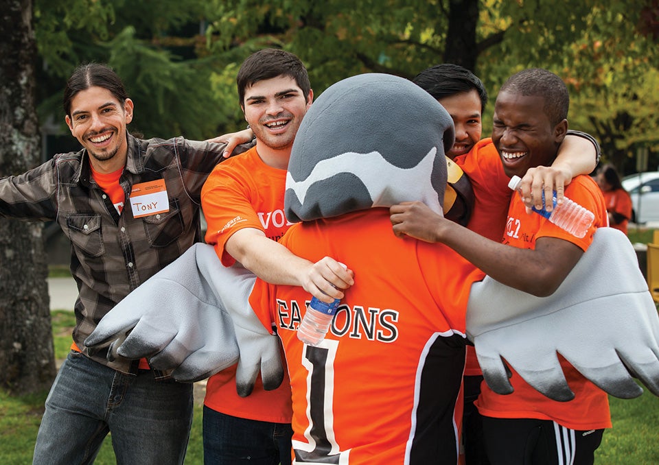 Students joyfully embracing the vibrant Langara Mascot, sharing smiles and a sense of community