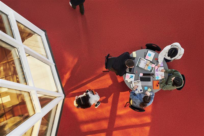 Photo shot from above: Four students studying at a table in T-building on Langara's Main Campus.