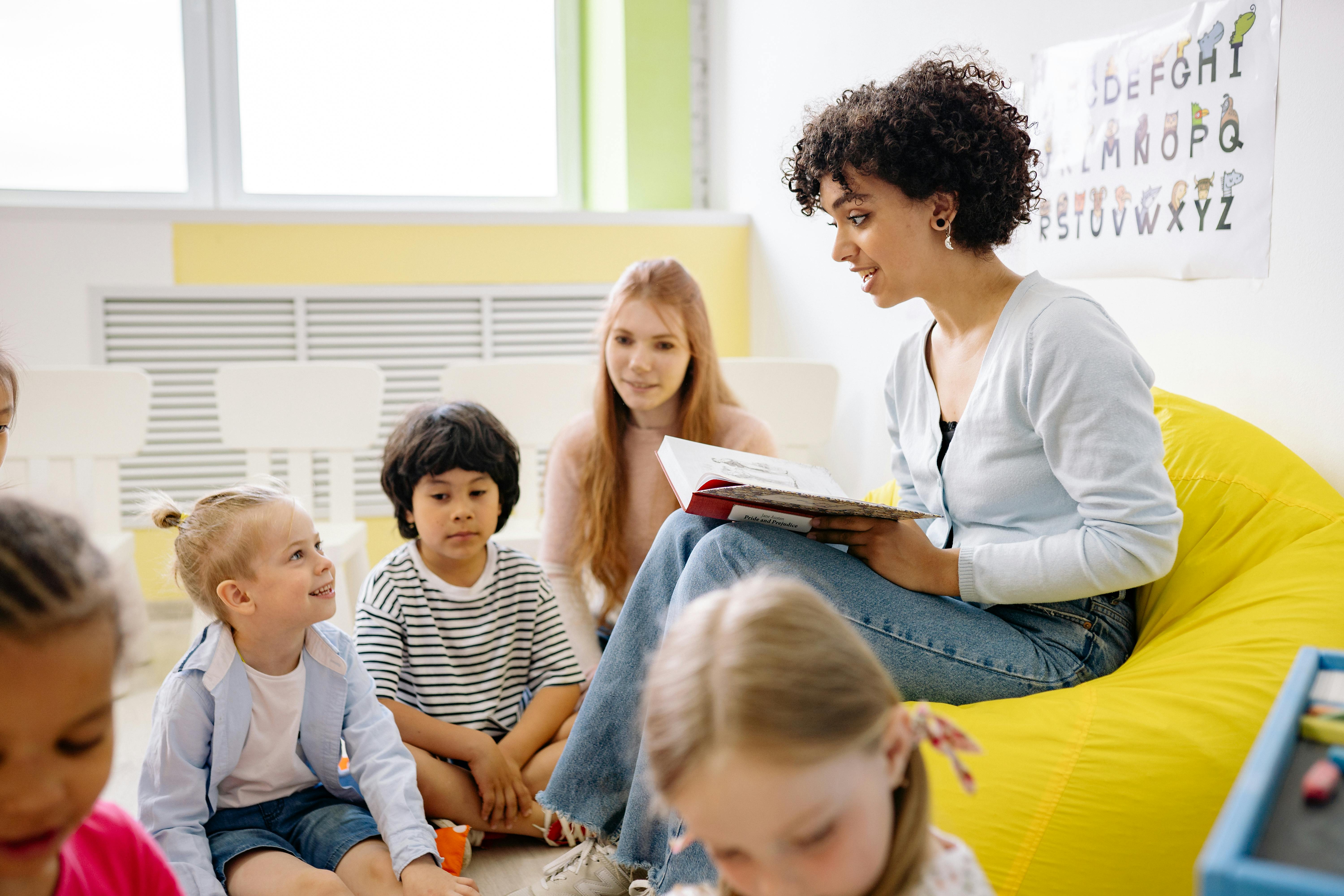 Stock image of a teacher reading to children.