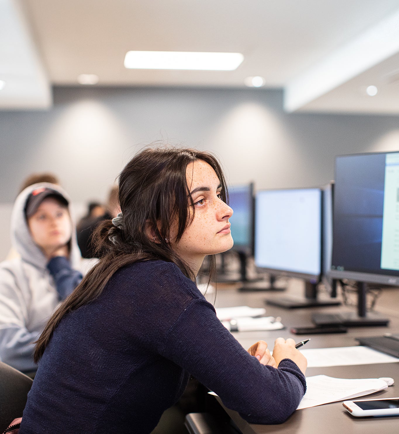 student at a computer with a thoughtful expression