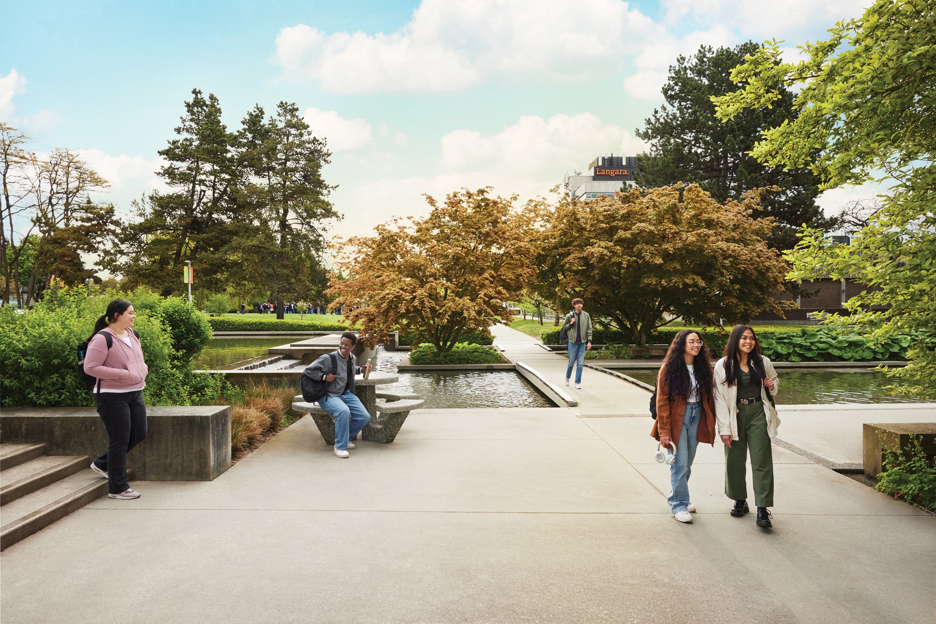 Students walking near the reflective pond at Langara College's campus located in the heart of Vancouver, British Columbia, Canada.