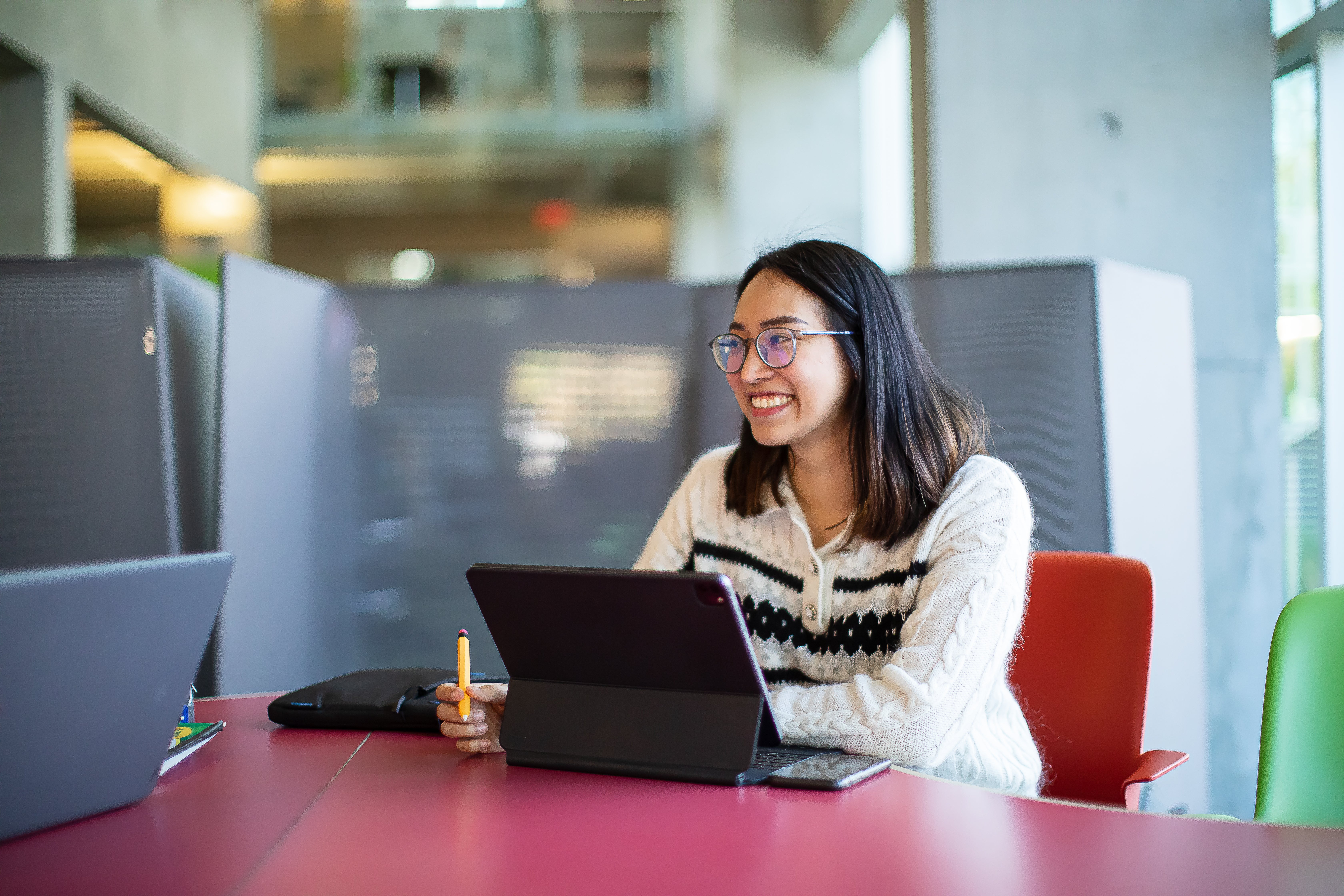 Female student sitting at a table in front of laptop computer.