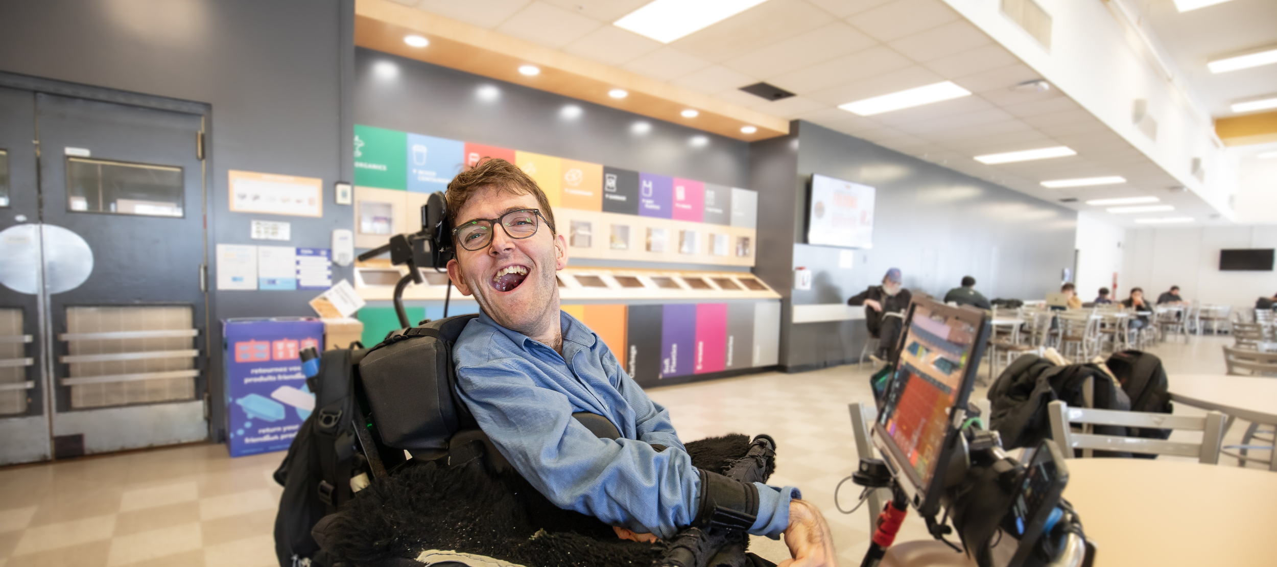 Student Ben Fullerton smiling in the cafeteria during a break in his classes.
