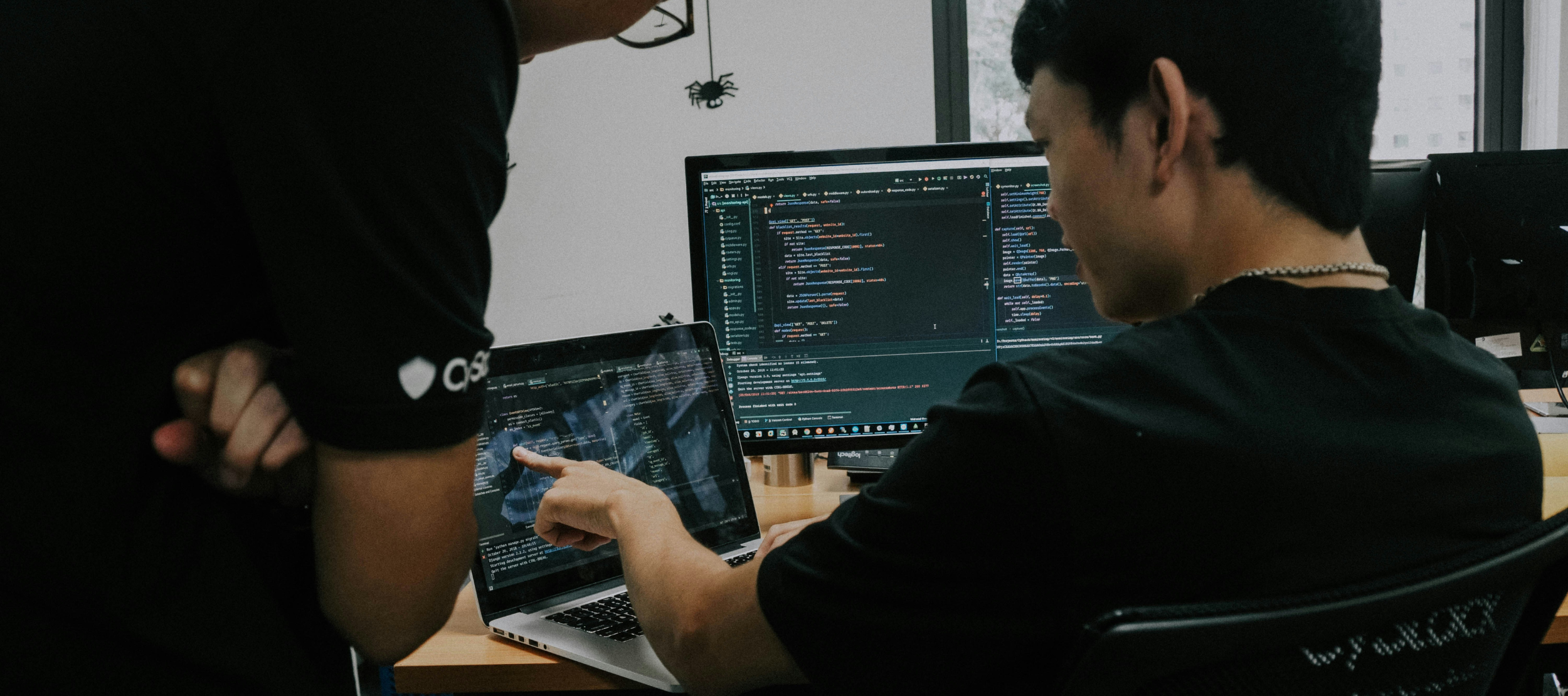 Two men collaborating on work using computers.
