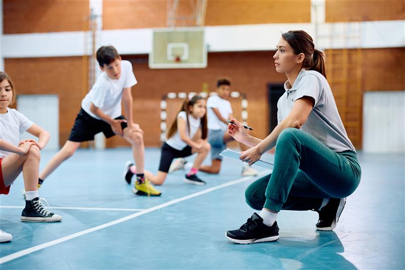 A woman assessing a young group of athletes