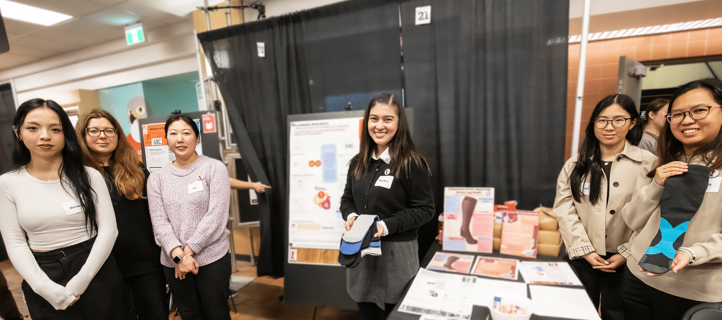 Nursing students smiling at their booth presenting their project at Applied Research Day 2026.