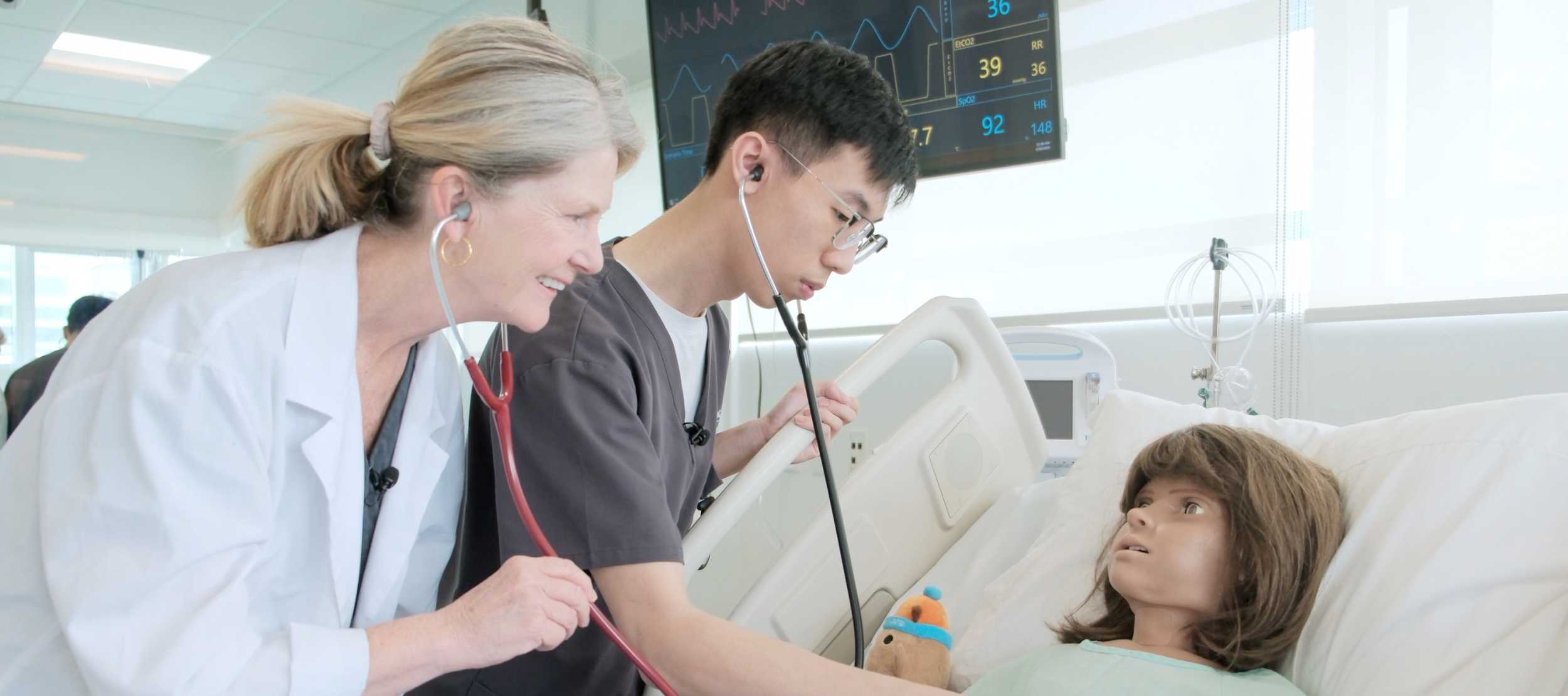Nursing student, Tim Pham, and instructor, Mary Peters, working with a high-fidelity mannequin in a simulated care scenario.