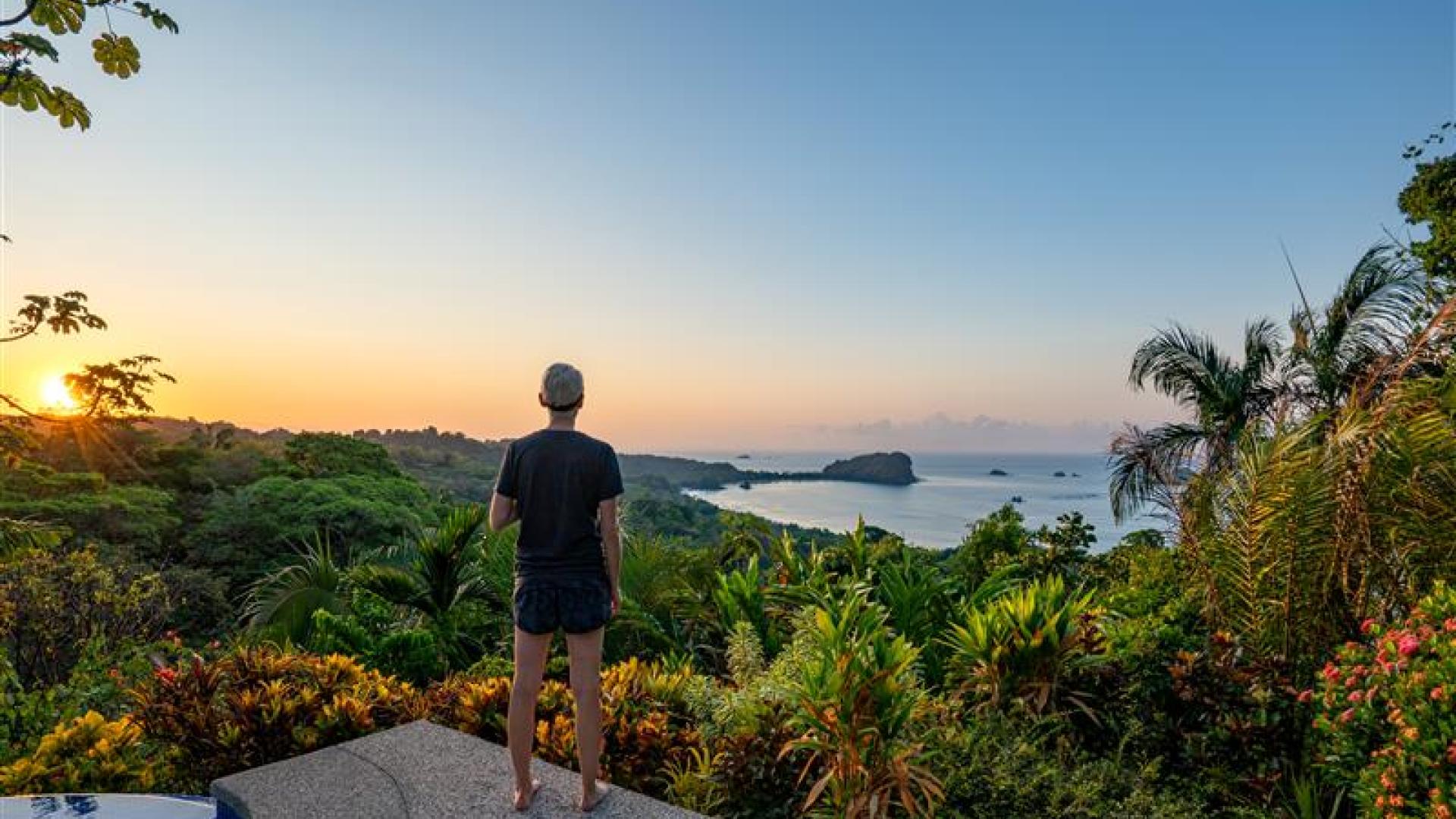 A student looks out at the lush view and nearby ocean in Costa Rica.