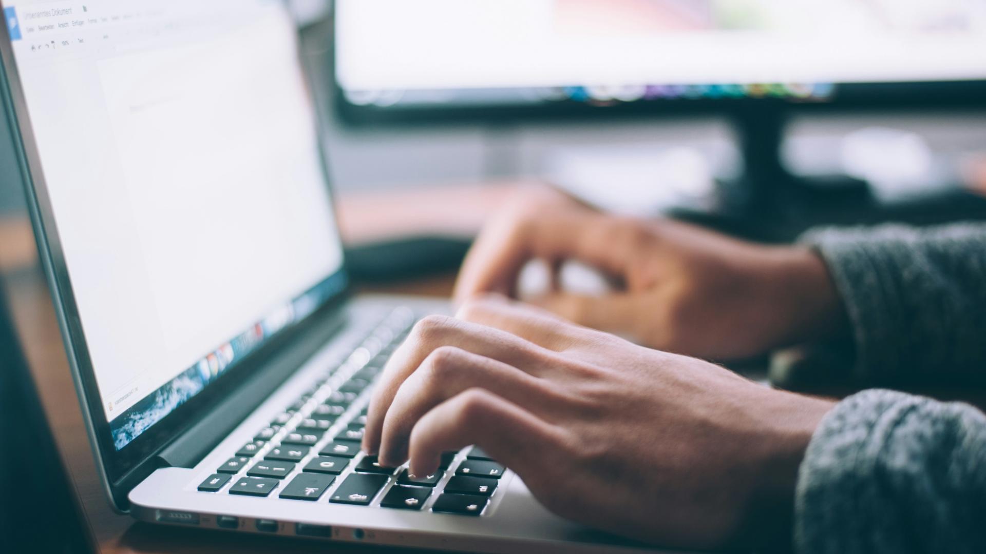 stock image of typing on a laptop