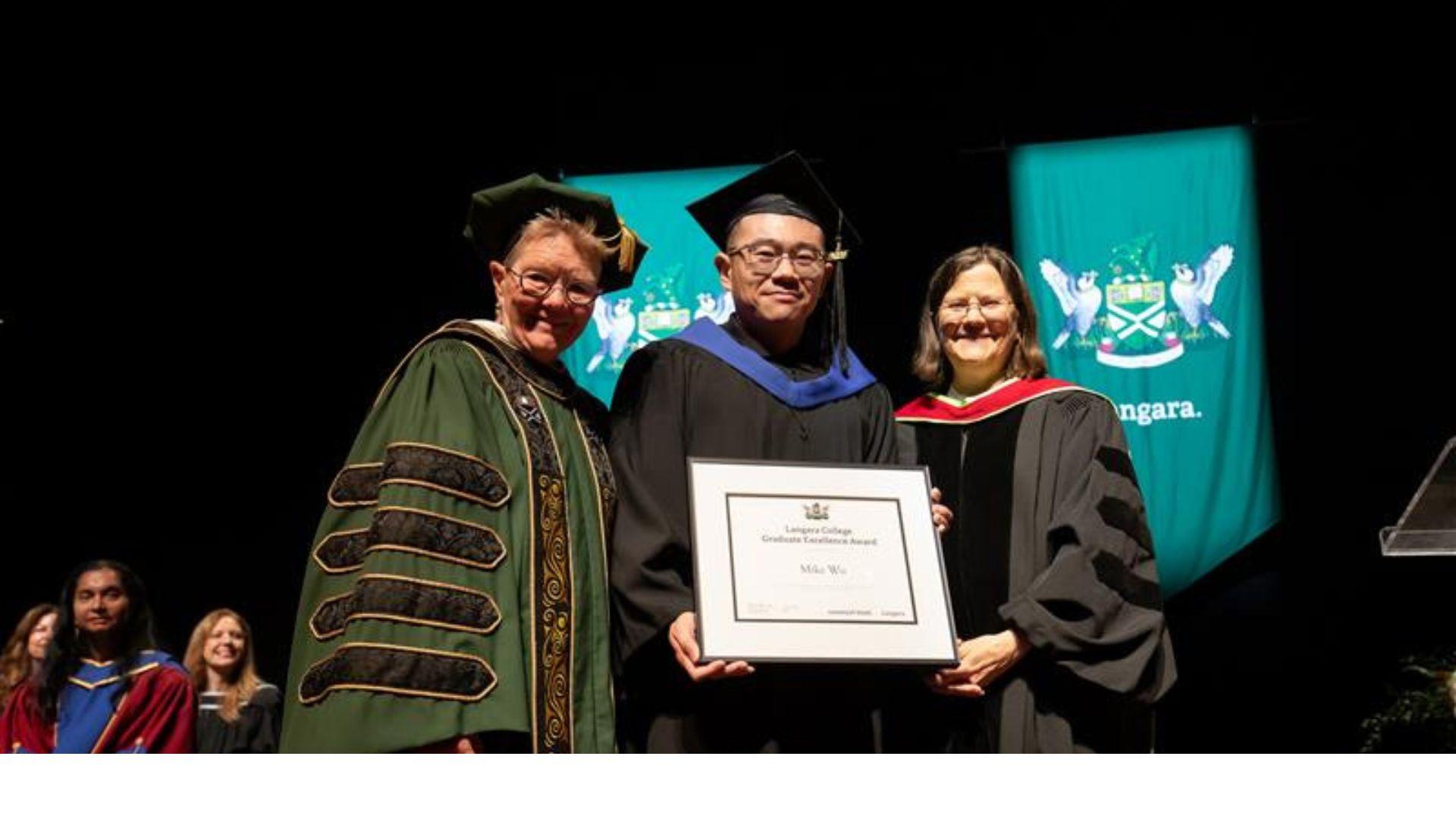 Dr. Paula Burns presents Bioinformatics graduate Mike Wu with his degree. 