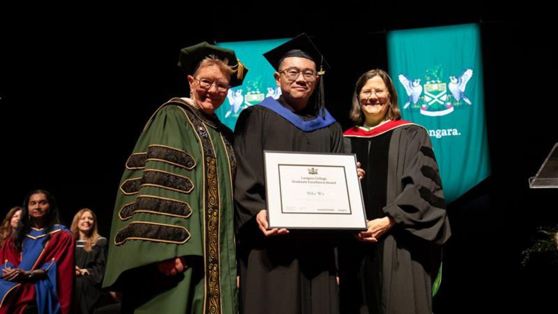 Dr. Paula Burns presents Bioinformatics graduate Mike Wu with his degree. 