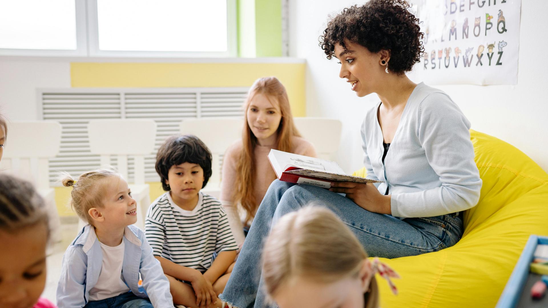 Stock image of a teacher reading to children.