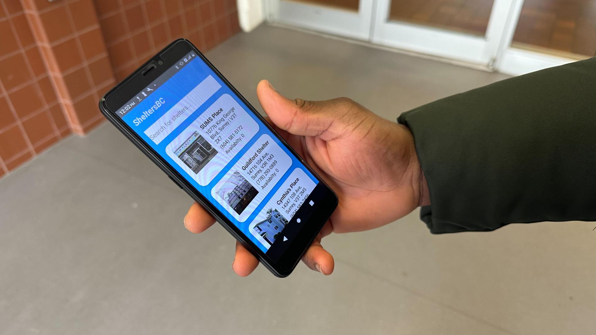 Man holding phone viewing SheltersBC app
