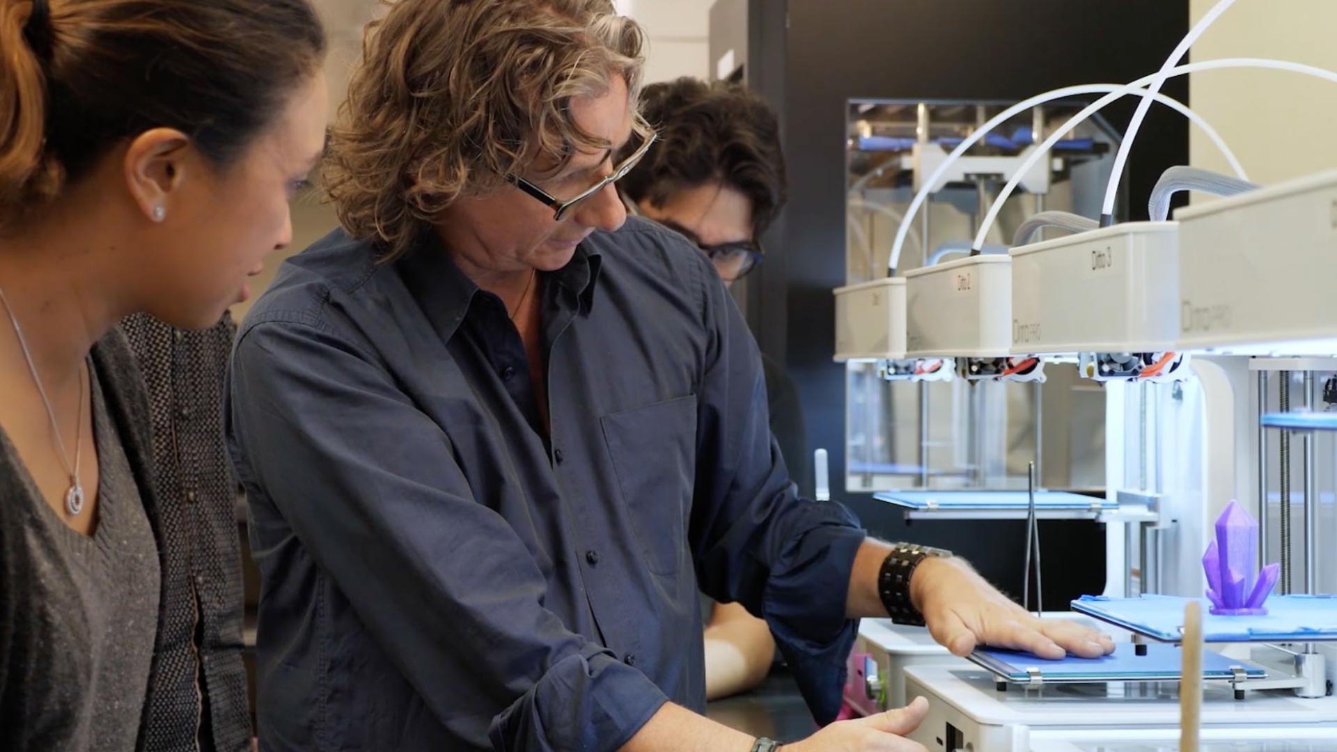 Instructor using a 3D printer