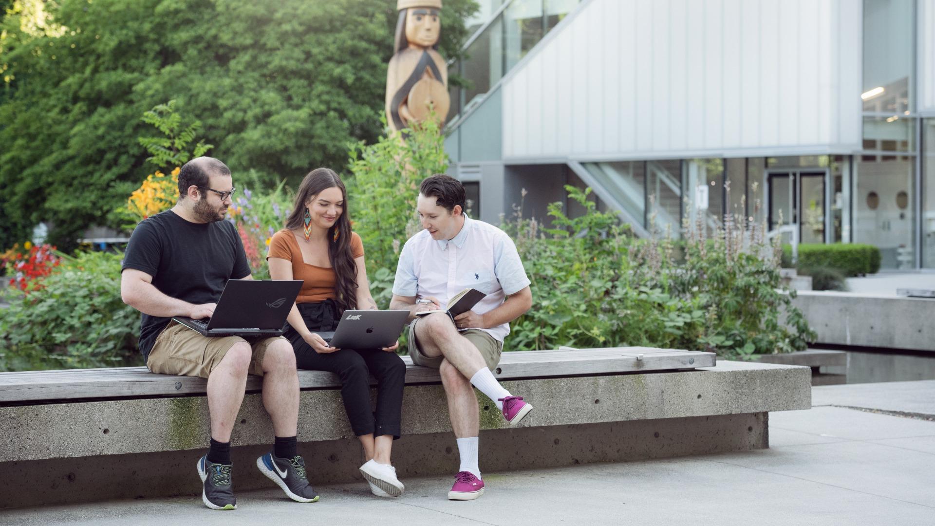 Tanis Wilson, Dylan MacPhee and an unnamed student write outside at Langara's main campus.