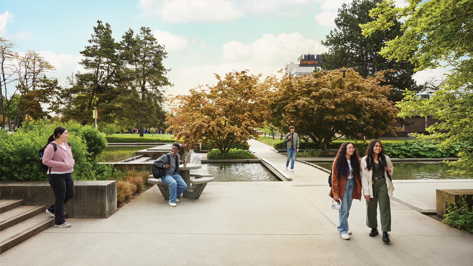 Students walking near the reflective pond at Langara College's campus located in the heart of Vancouver, British Columbia, Canada.