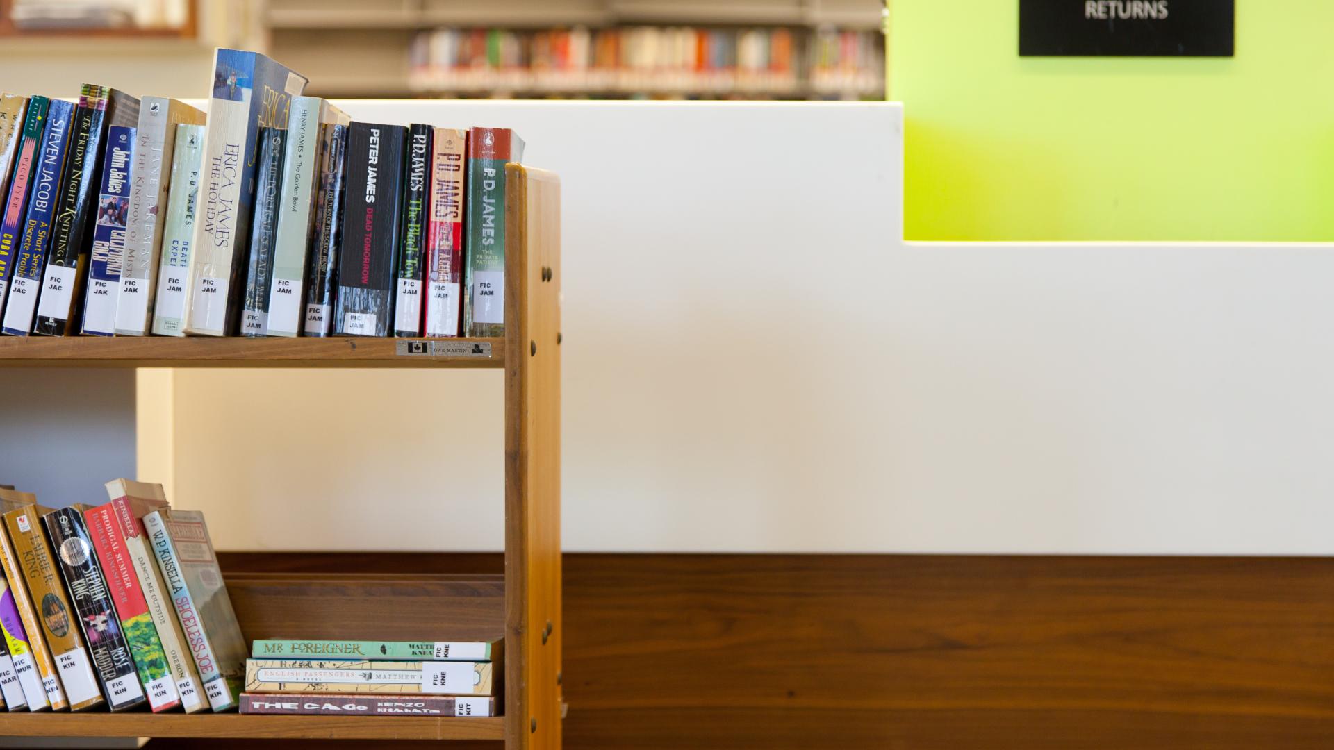Library book cart in front of a book return sign