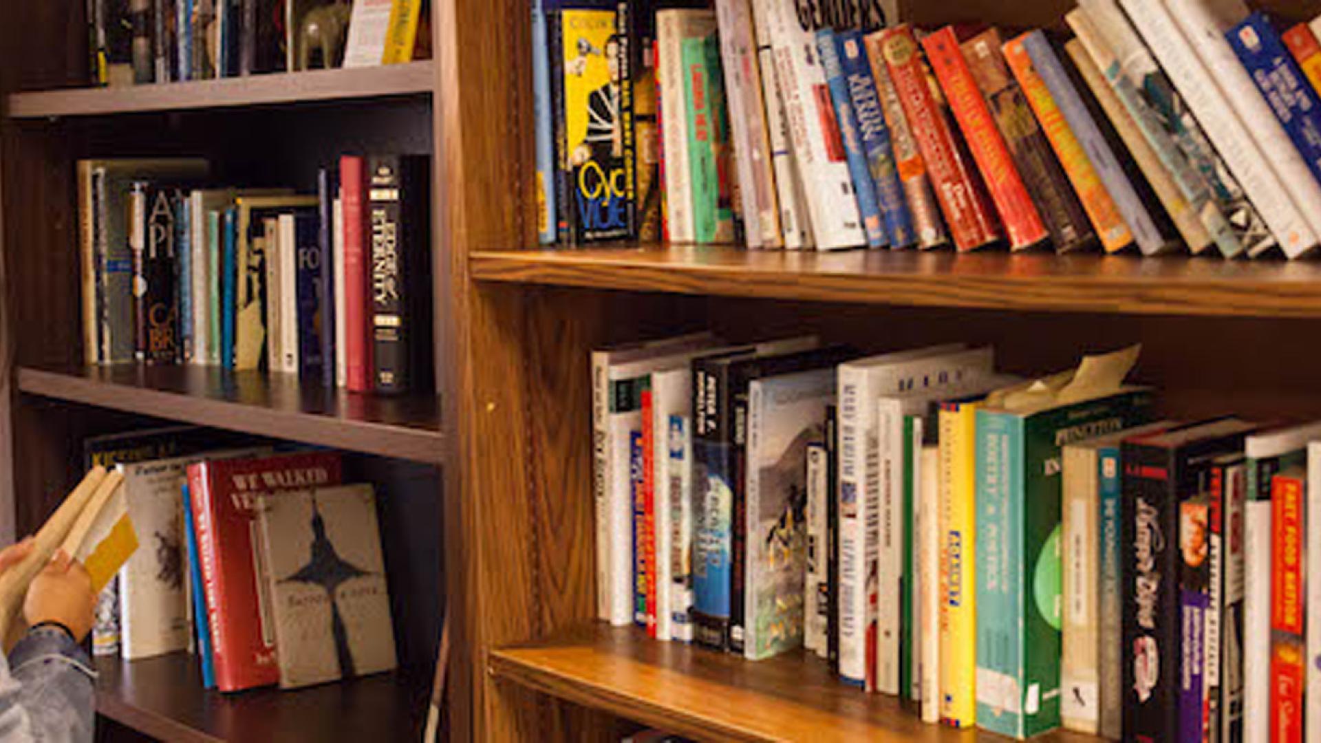 a woman looking at books on a shelf