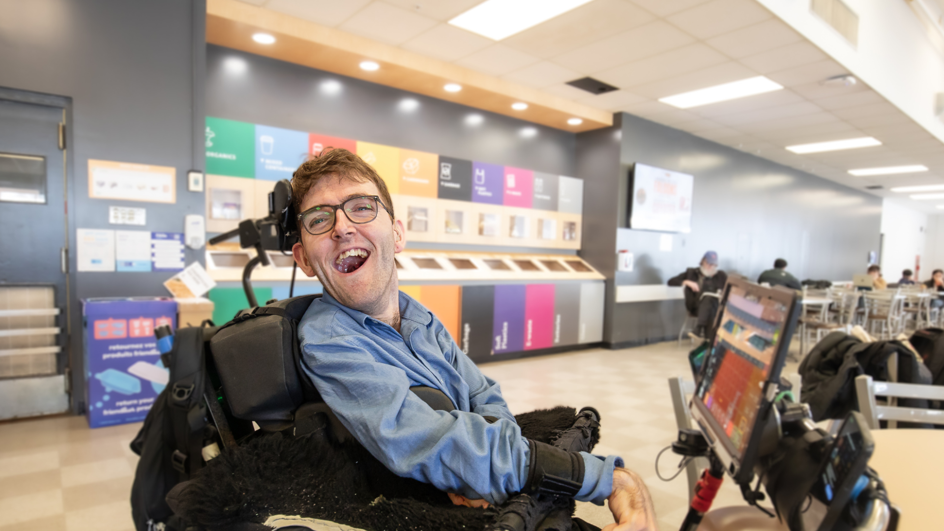 Student Ben Fullerton smiling in the cafeteria during a break in his classes.
