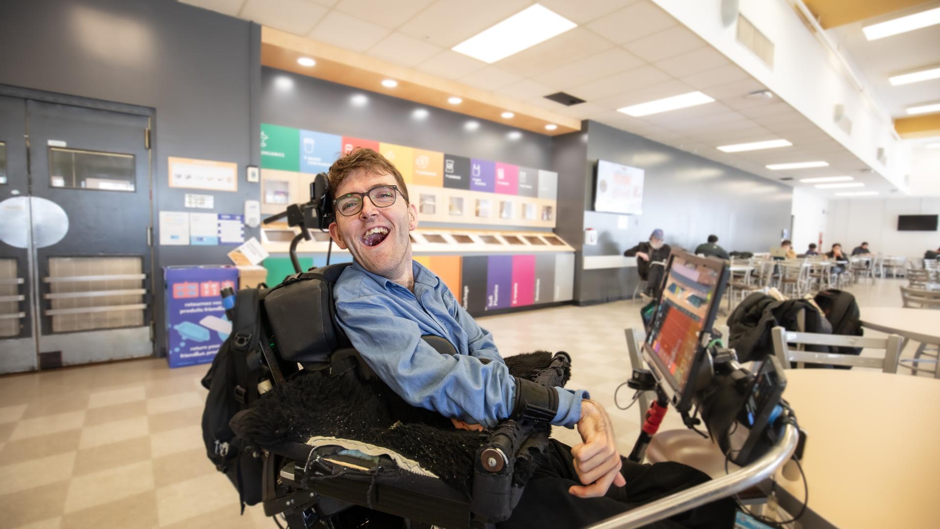 Student Ben Fullerton smiling in the cafeteria during a break in his classes.