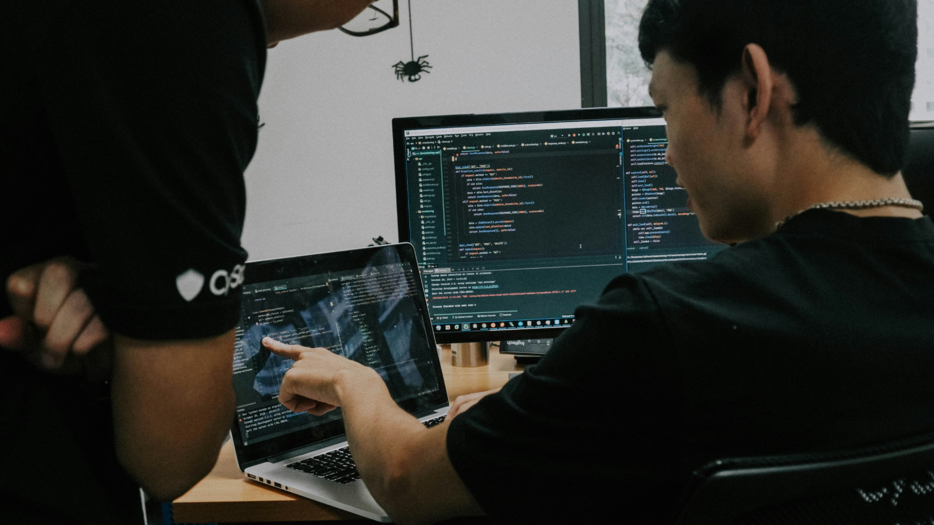 Two men collaborating on work using computers.