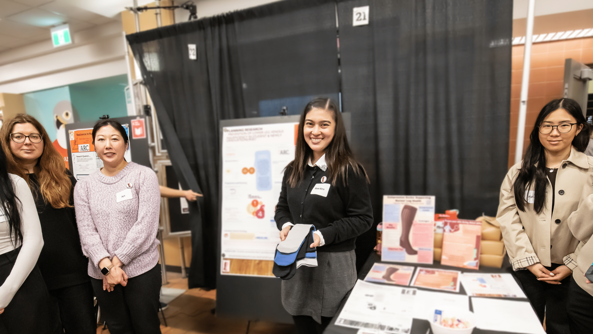 Nursing students smiling at their booth presenting their project at Applied Research Day 2026.