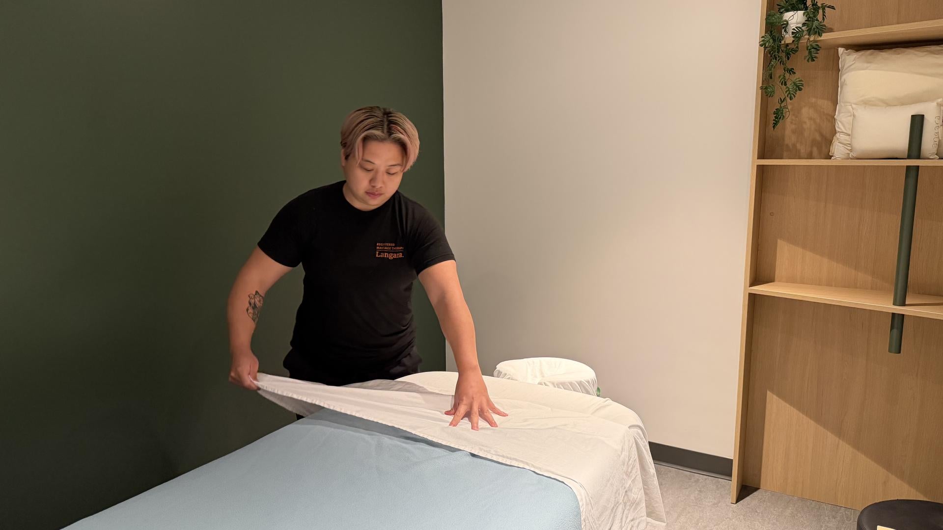 Second-year RMT student, Beverly Cheung, preparing a treatment room in the new student clinic.