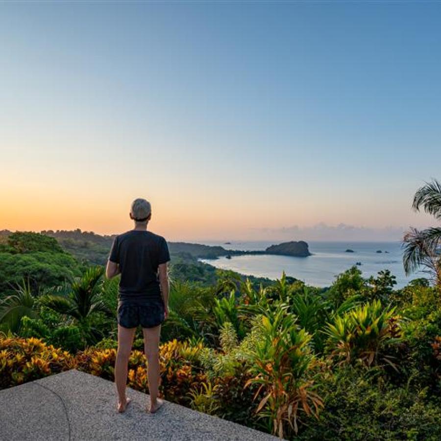 A student looks out at the lush view and nearby ocean in Costa Rica.