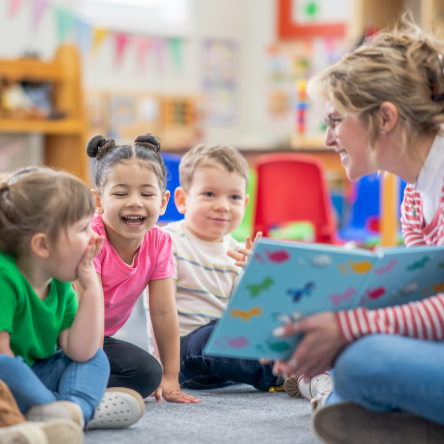 Early childhood educator with four students.