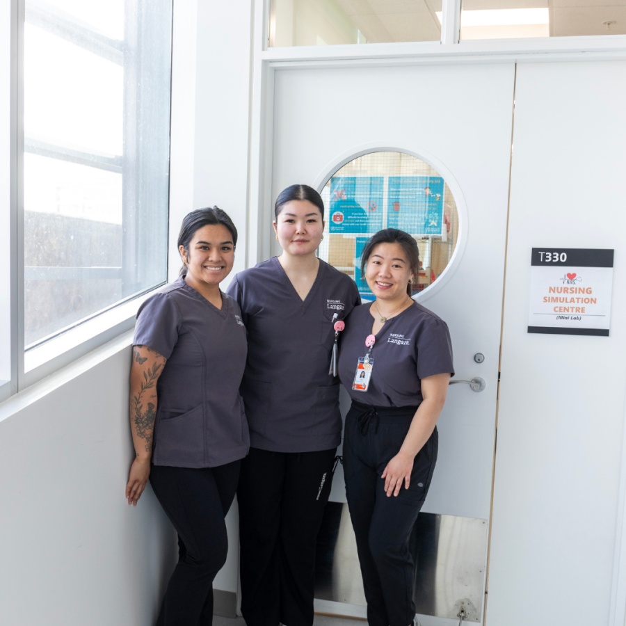Three students in front of the Langara Nursing Lab