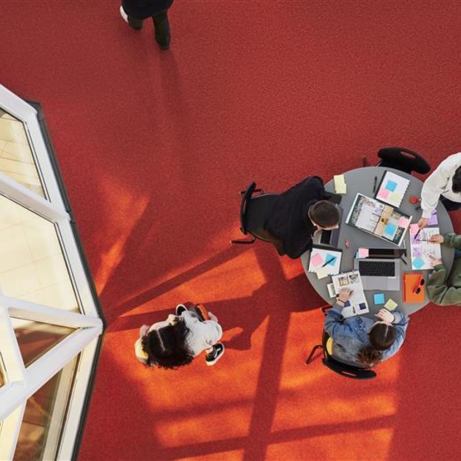 Photo shot from above: Four students studying at a table in T-building on Langara's Main Campus.