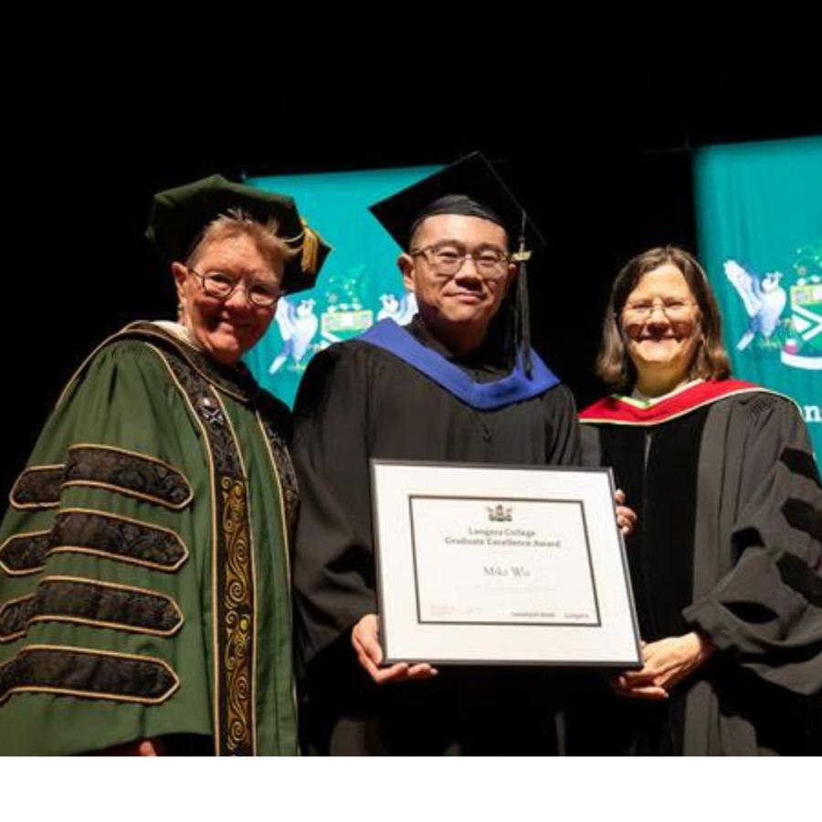 Dr. Paula Burns presents Bioinformatics graduate Mike Wu with his degree. 