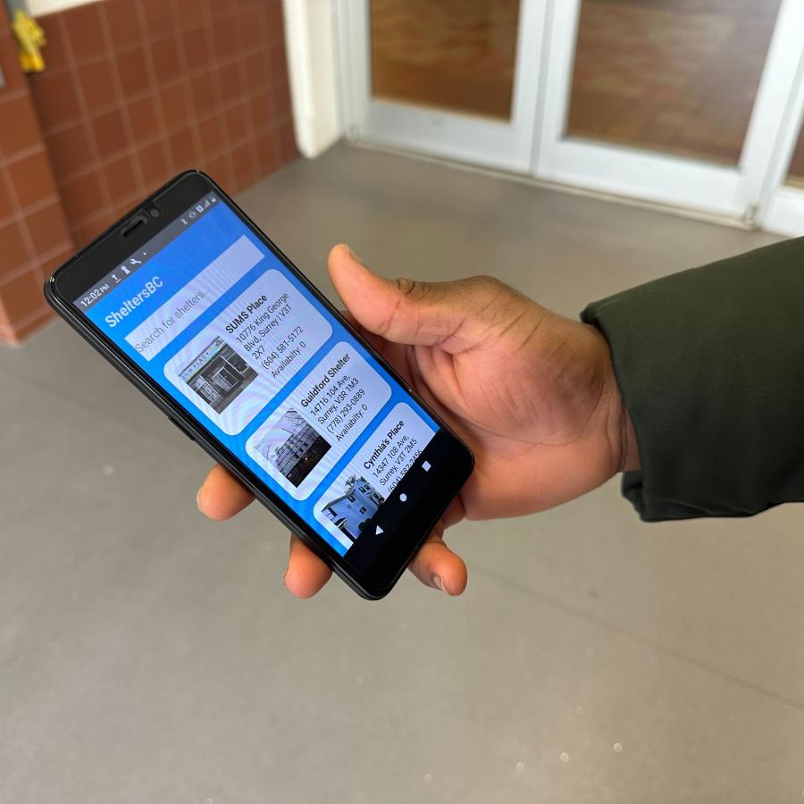 Man holding phone viewing SheltersBC app