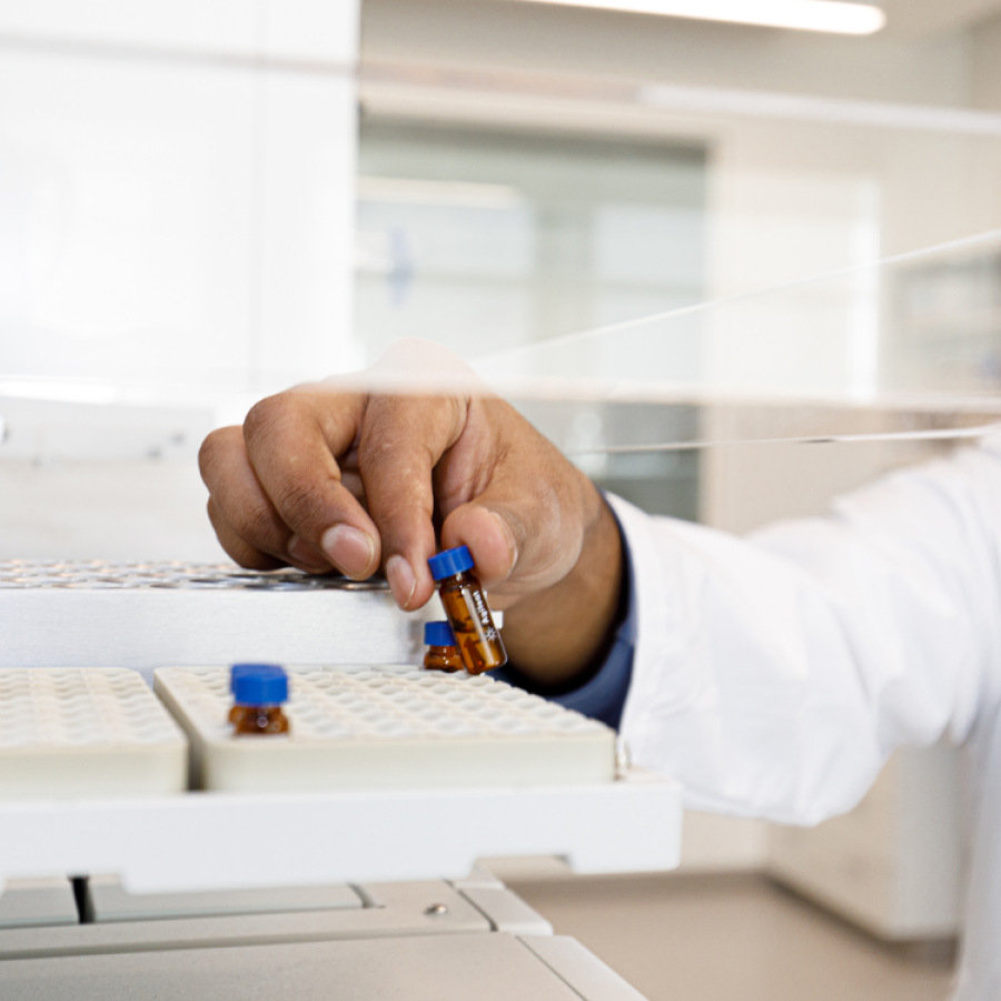 Chemistry student holding small glass vial