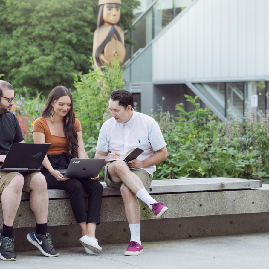 Tanis Wilson, Dylan MacPhee and an unnamed student write outside at Langara's main campus.