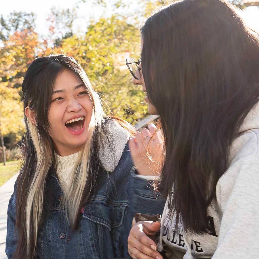 Two female-presenting students talk on Langara's main campus.