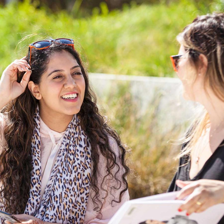Two female-presenting students talk on Langara's main campus.