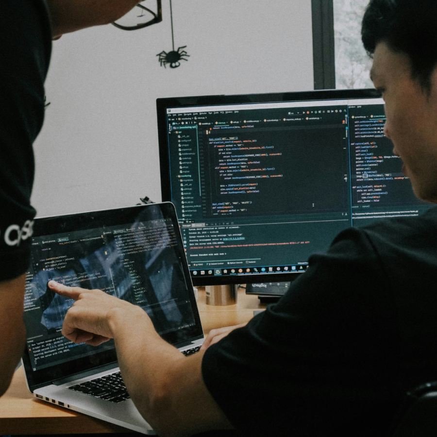 Two men collaborating on work using computers.