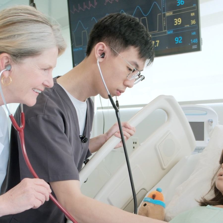 Nursing student, Tim Pham, and instructor, Mary Peters, working with a high-fidelity mannequin in a simulated care scenario.