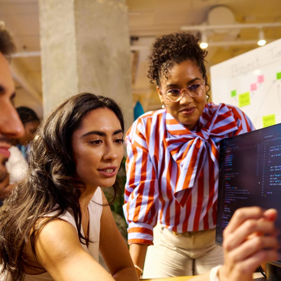 Three college students collaborating at a computer work station.