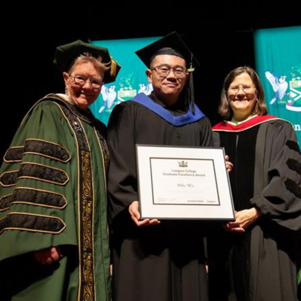 Dr. Paula Burns presents Bioinformatics graduate Mike Wu with his degree. 