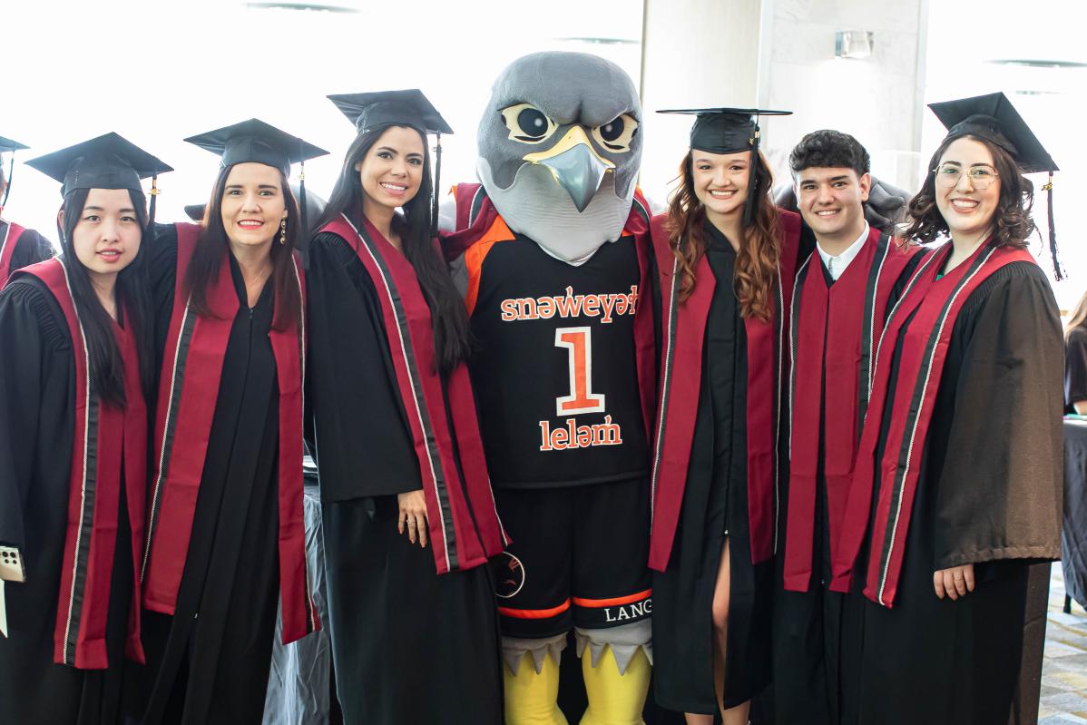 Graduating students pose with Flash at convocation.