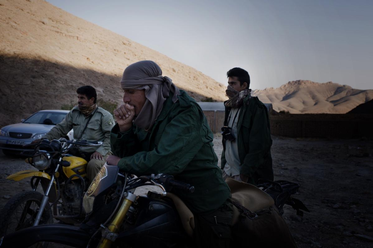 Three bikers in the desert, cast in shadow.