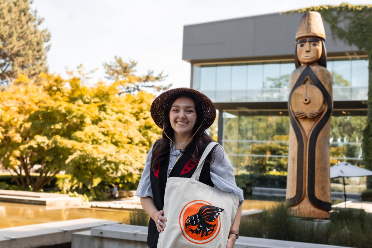 Musqueam alum, Amber Cornick, with her design of a Coast Salish-inspired Indigenous Langara Falcons logo, printed on a tote bag.